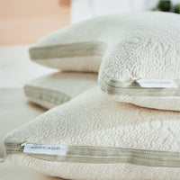 Two Avocado Side-Sleeper Pillows stacked on a bed