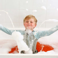 Child in a bathtub filled with bubbles, enjoying a bath.