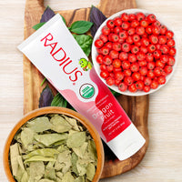 Radius toothpaste with dragon fruit and leafy greens on a wooden board