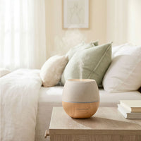Aroma diffuser on a wooden table with a cozy living room background