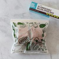 Compostable gallon zipper bag with packaging on a marble surface