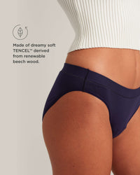 Navy blue underwear worn by a person on a light gray background, with text about TENCEL material.