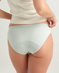 Light blue underwear worn by a person on a plain background