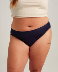 Person wearing navy blue underwear on a plain background