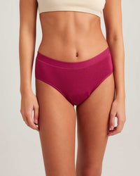 Person wearing magenta high-waisted bikini bottoms on a light gray background