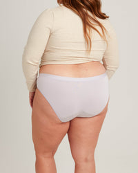 Person wearing light gray underwear with a plain background