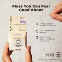 A hand holds a spool of Radius Silk Floss dental floss next to its packaging box. The packaging is cream and beige with black and purple text, and the floss itself is a thin white thread.