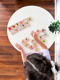 Child playing with wooden blocks on a white round table