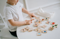 Child playing with wooden blocks on a white surface
