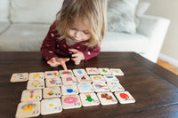 Child playing with educational wooden tiles on a table