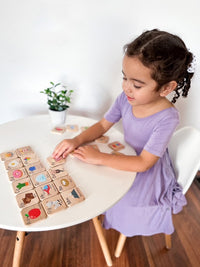 Child playing with wooden blocks at a table indoors