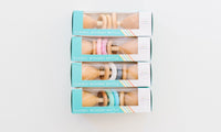 Three boxes of classic wooden rattles on a white background