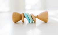 Wooden baby rattle with colorful beads on a white surface
