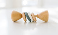Wooden baby rattle with colorful beads on a white background