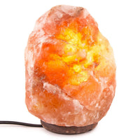 Himalayan salt lamp with a warm glow on a white background