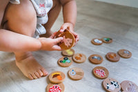 Child playing with wooden toys on a wooden floor