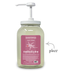Glass shampoo bottle with pump and pink label on a white background